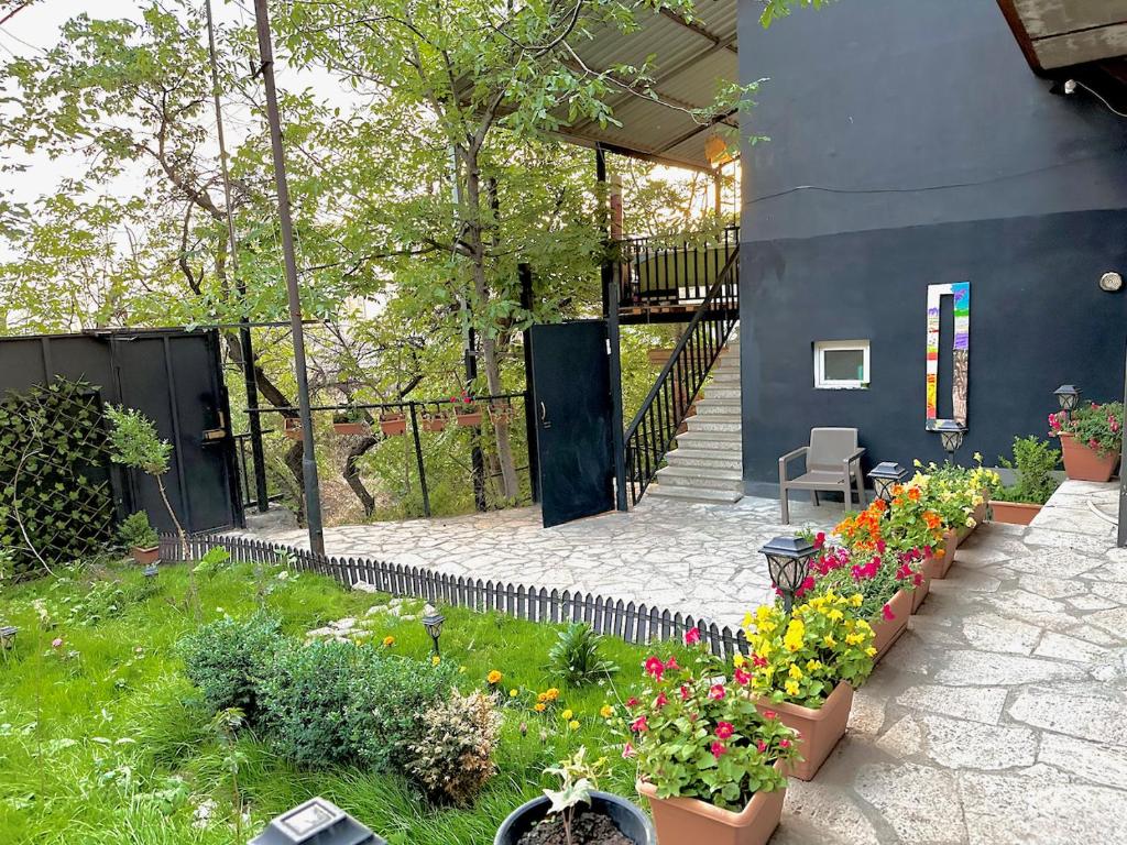 a garden with plants and flowers in a yard at Cosy Studio with Beautiful Garden in Yerevan