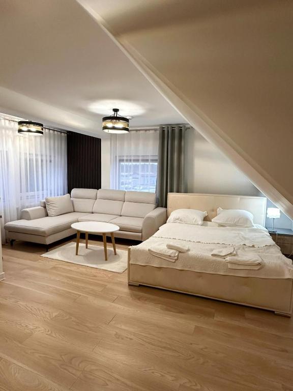 sypialnia z łóżkiem, kanapą i stołem w obiekcie Motel Za Miedzą w mieście Bralin