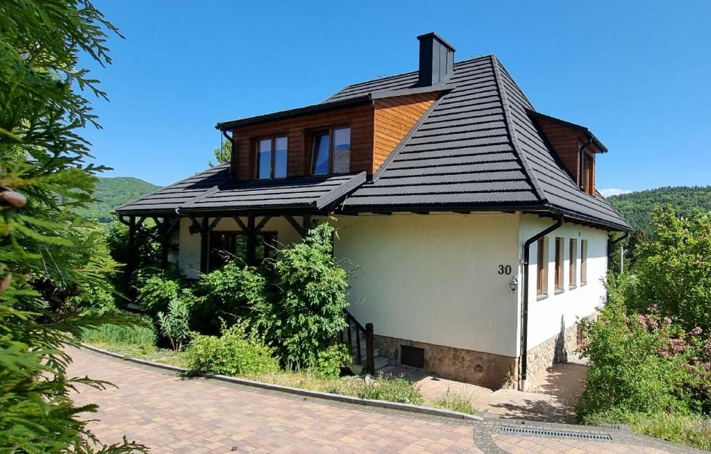 una casa con techo de gambrel en una carretera en Mountain House, en Ustrzyki Dolne