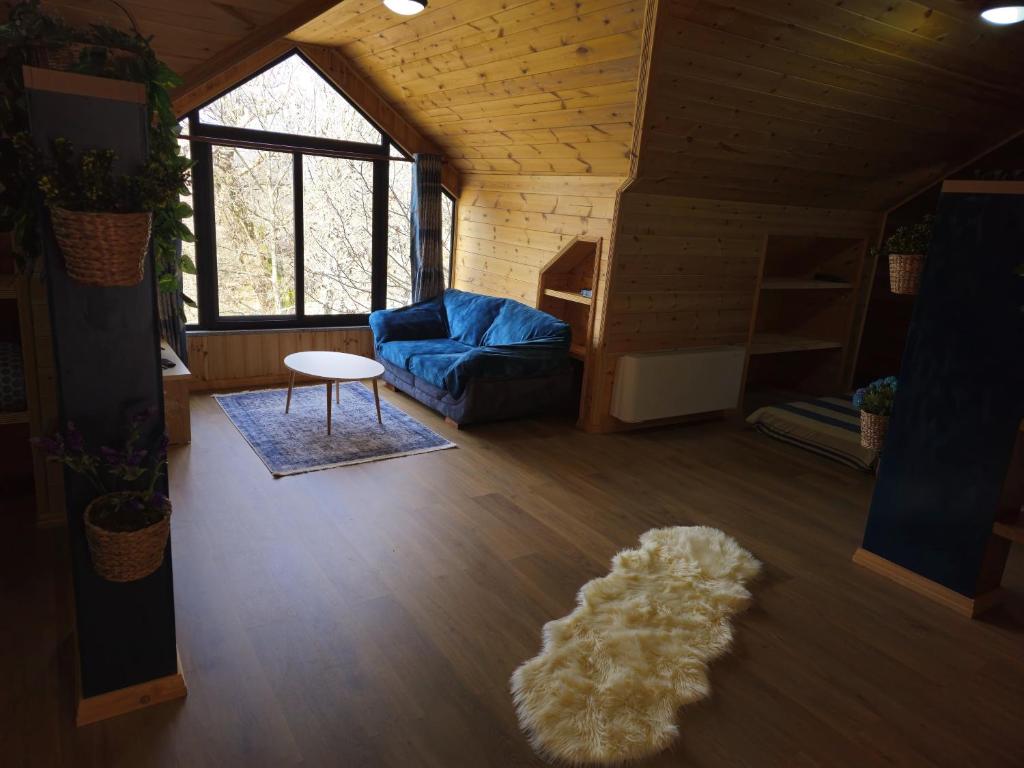 ein Wohnzimmer mit einem blauen Sofa und einem Teppich in der Unterkunft Bar Restorant Geshtenja 