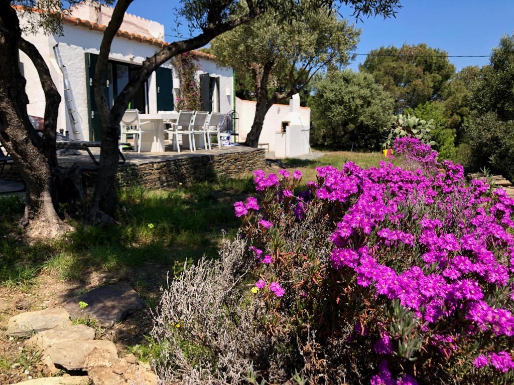 einen Garten mit lila Blumen vor einem Haus in der Unterkunft Maison de pêcheur superbe vue mer, grand jardin in Cadaqués