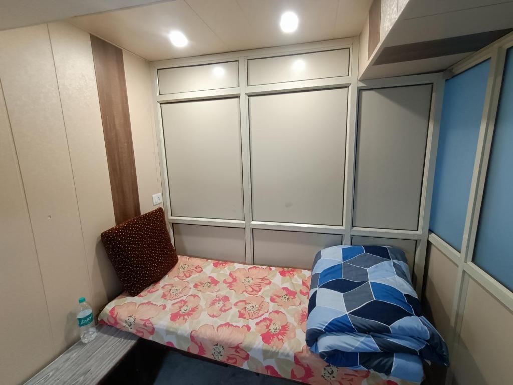 Habitación pequeña con cama y silla en snooze 3, en Panchkula