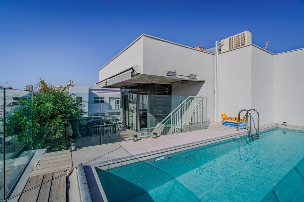 a house with a swimming pool next to a building at Shenkin Dream - 4 BR in Tel Aviv