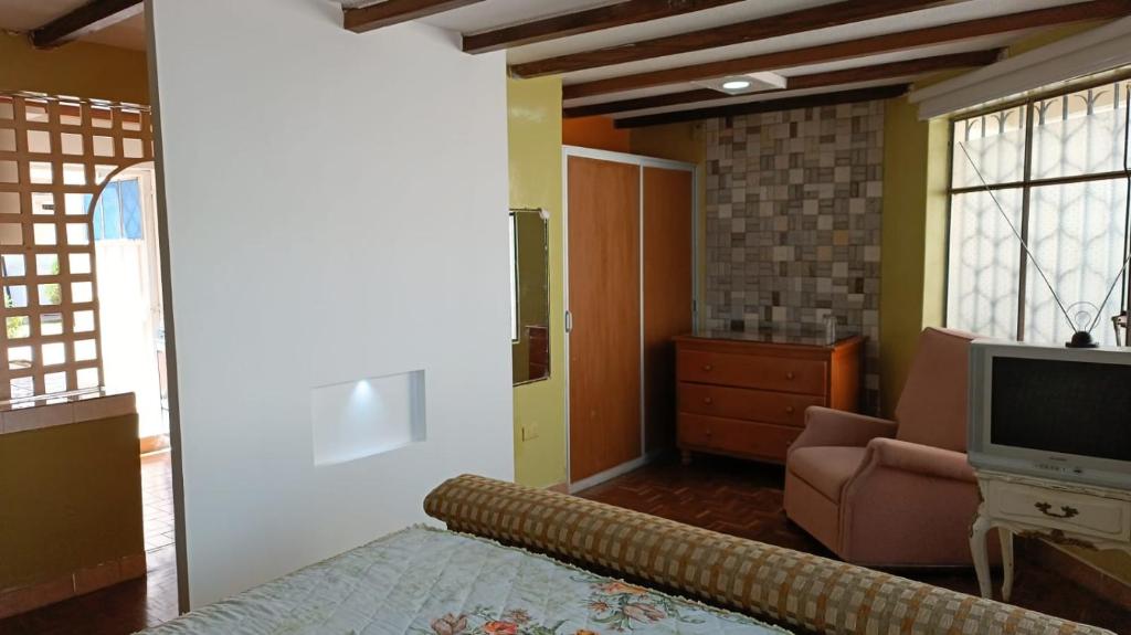 een woonkamer met een bank en een televisie bij Casa de La Hiedra.Alojamiento para ejecutivos. in Sangolquí