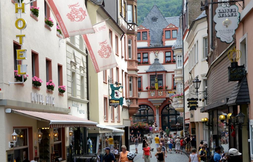 a group of people walking down a street with buildings at Hotel Binz in Bernkastel-Kues