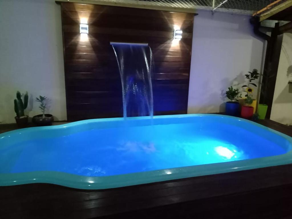 a blue bath tub with a water fountain at Casa com Piscina perto da praia in Salvador