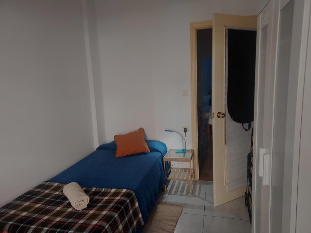 sypialnia z łóżkiem z niebieskim kocem i otwartymi drzwiami w obiekcie Cozy Private Room 1 w Walencji