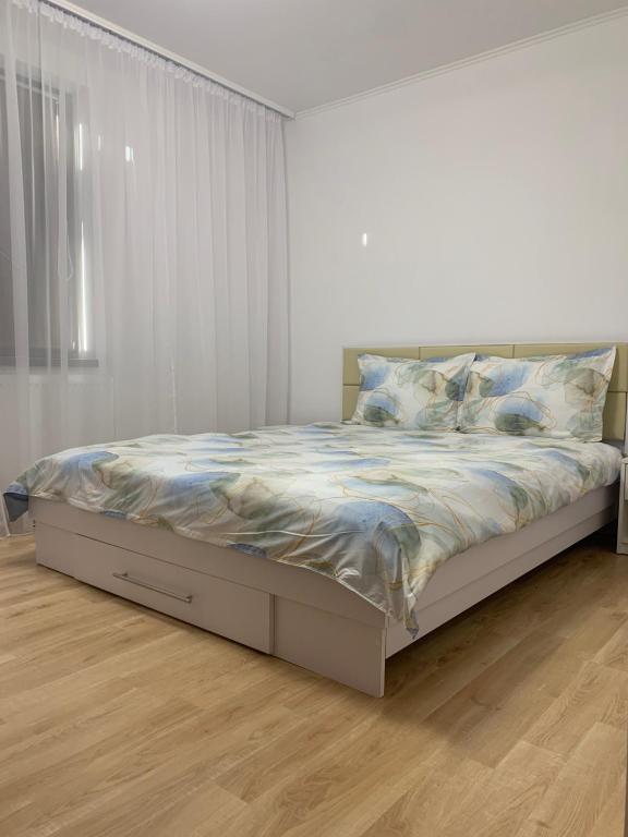 een bed in een witte slaapkamer met een witte muur bij Apartament central in Râmnicu Vâlcea