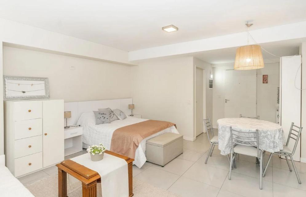 1 dormitorio blanco con 1 cama, mesa y sillas en Monoambiente moderno con Amenities Nuñez en Buenos Aires