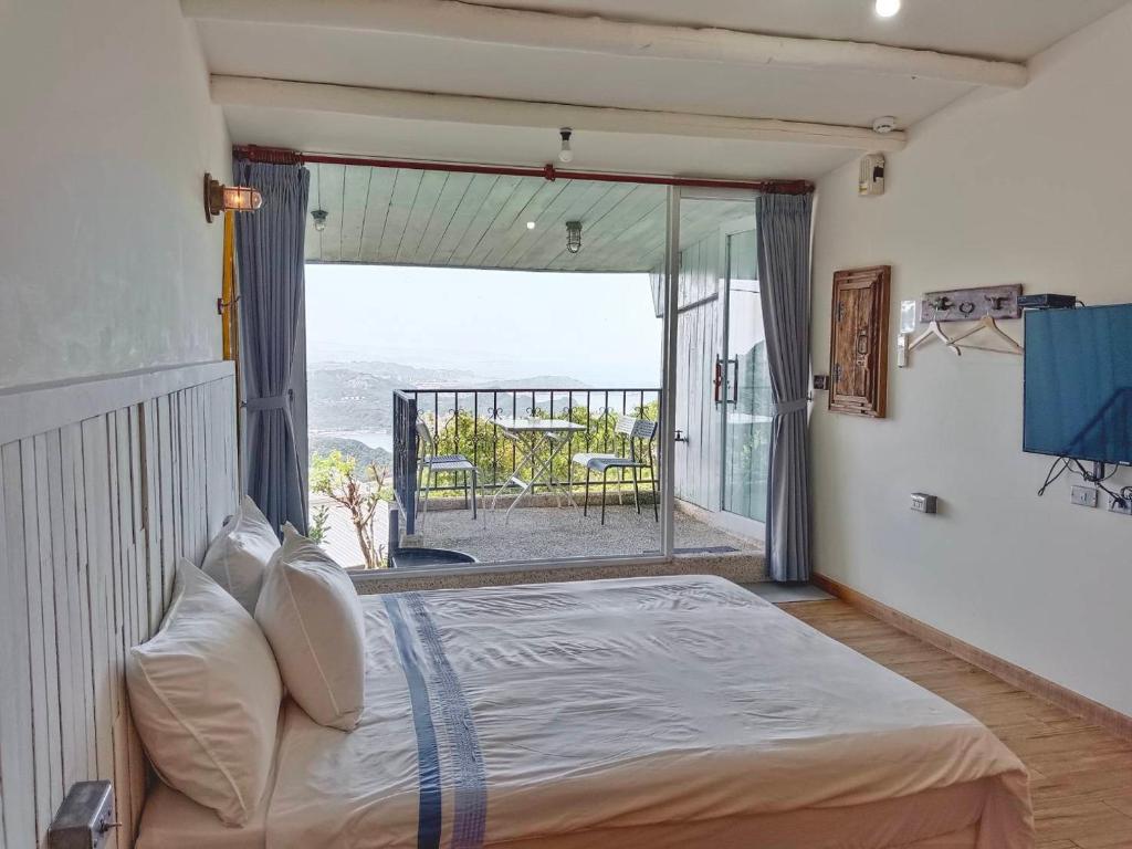 a bedroom with a bed and a view of the ocean at Flower House B&B in Jiufen