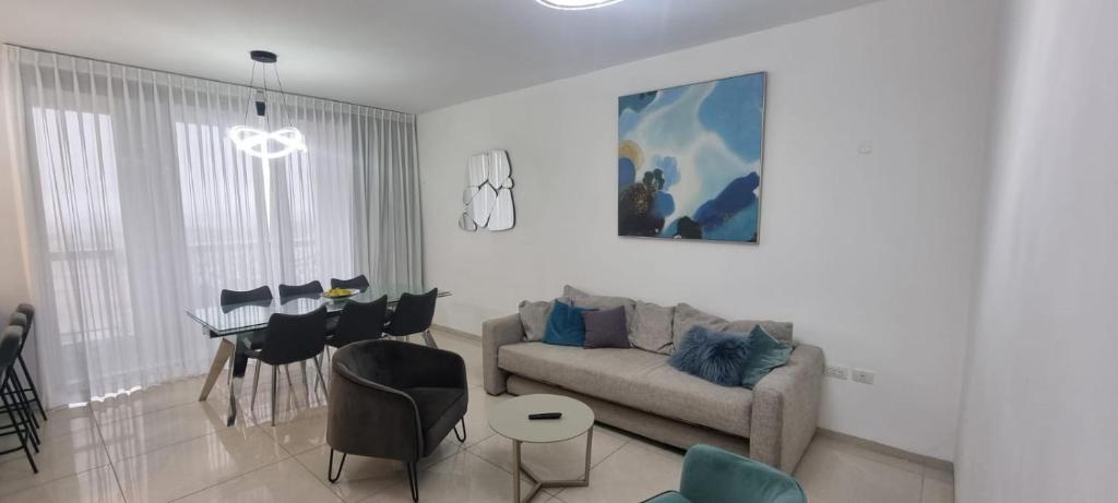 uma sala de estar com um sofá e uma sala de jantar em JTower Royal Suites - Alefimmoed em Jerusalém