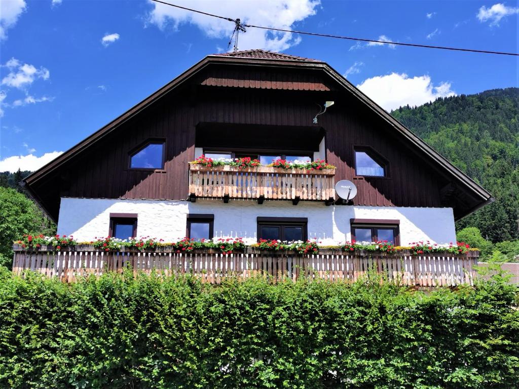 una casa con un balcón con flores. en Alpenview Apartments Hauser en Reisach