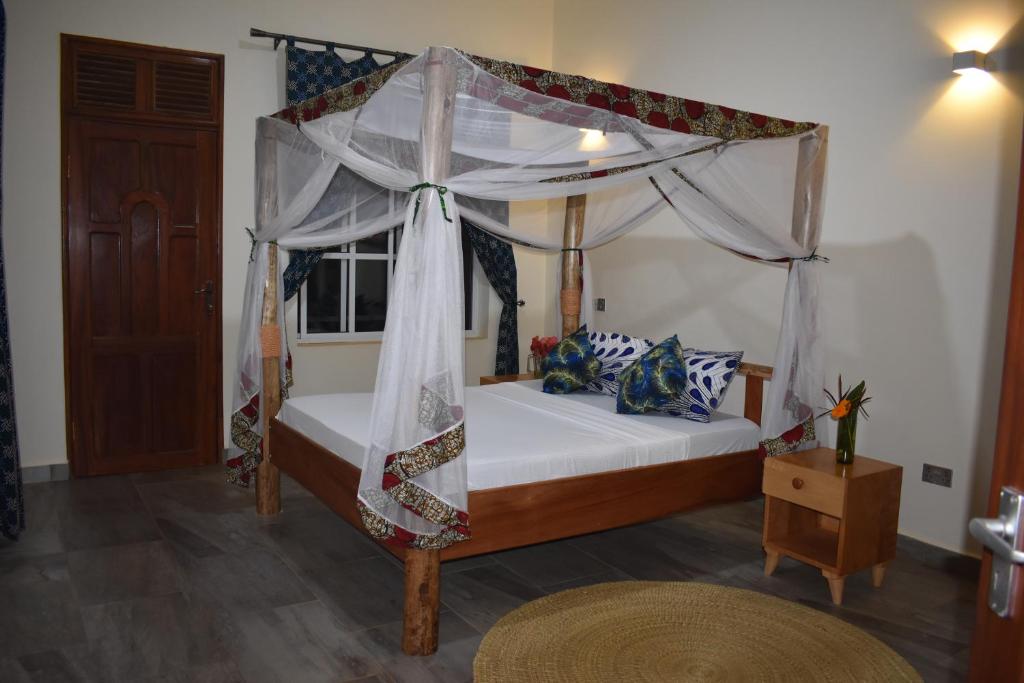 um quarto com uma cama de dossel e uma janela em Kilimanjaro Accommodation em Msaranga