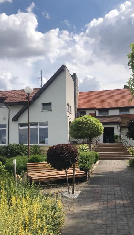 budynek z dwoma ławkami przed budynkiem w obiekcie Motel Za Miedzą w mieście Bralin