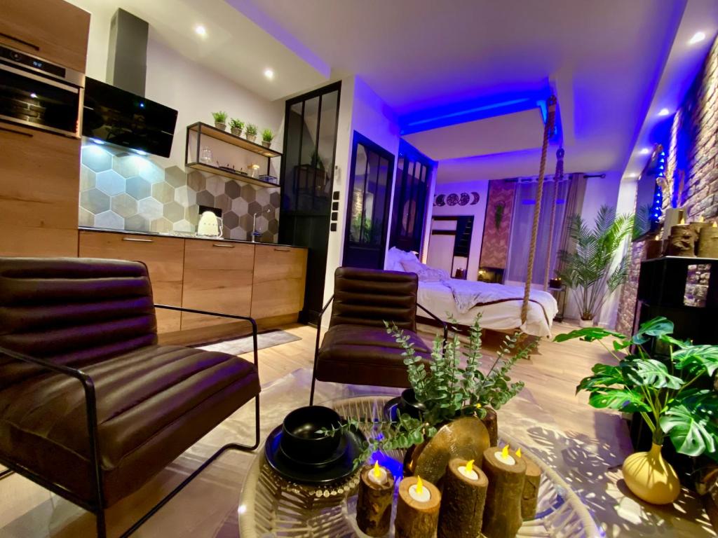 a room with a bed and a couch and chairs at Saphir Spa - Sauna Balnéo Chromothérapie Massage in Amiens