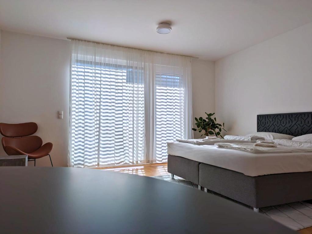 ein Schlafzimmer mit einem großen Bett und einem großen Fenster in der Unterkunft Modern Apartments Vienna in Wien