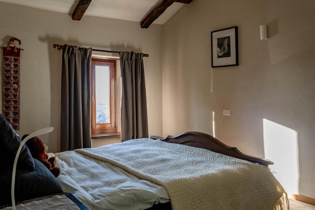 um quarto com uma cama e uma janela em Number 10 Locanda B&B em Belvedere Langhe
