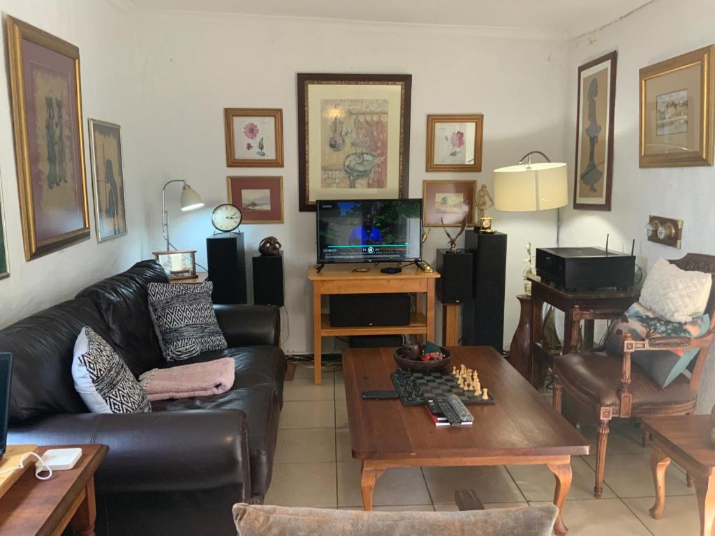 un soggiorno con divano e tavolo di Coz Guesthouse in Randburg a Johannesburg