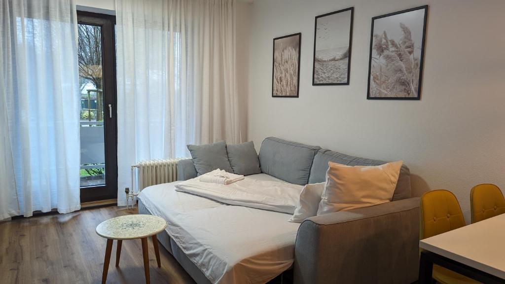 a living room with a couch and a table at BRAN: Design - Apartment Küche, Parken ,Netflix in Bad Rothenfelde