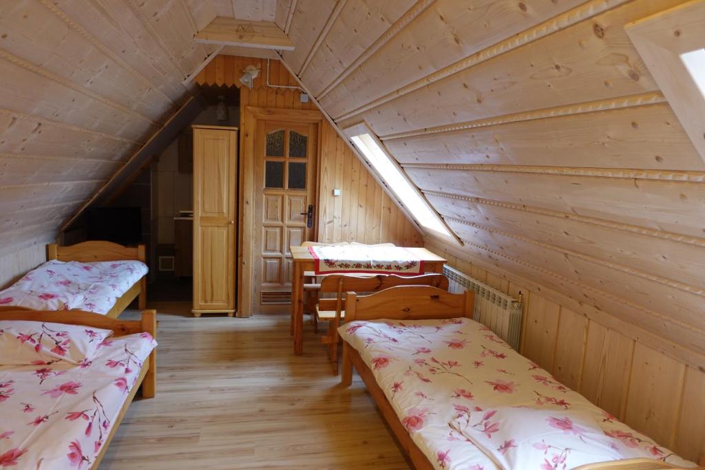 a room with two beds and a table in a cabin at Domek Białka Tatrzańska in Białka Tatrzańska