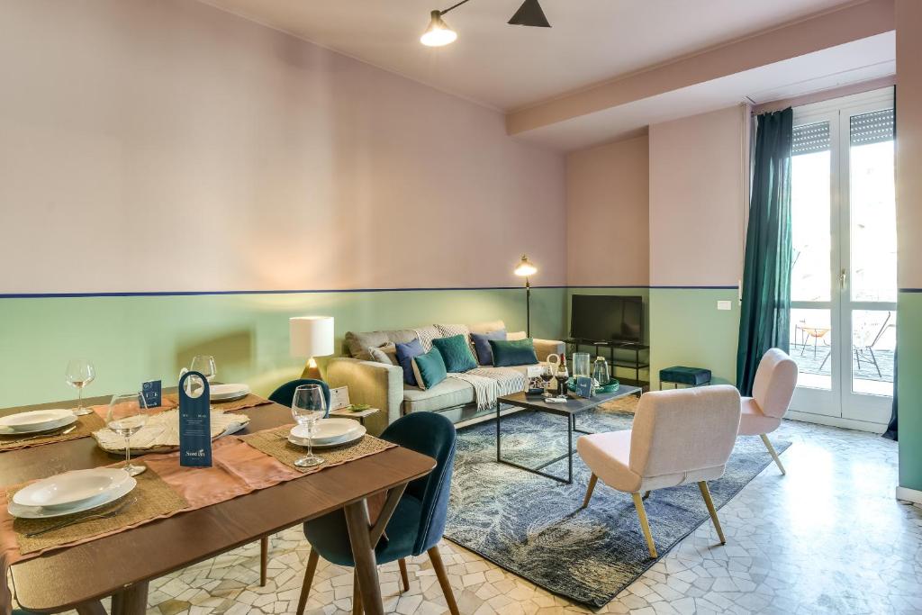 ein Wohnzimmer mit einem Tisch, Stühlen und einem Sofa in der Unterkunft Sweet Inn - Ariberto in Mailand