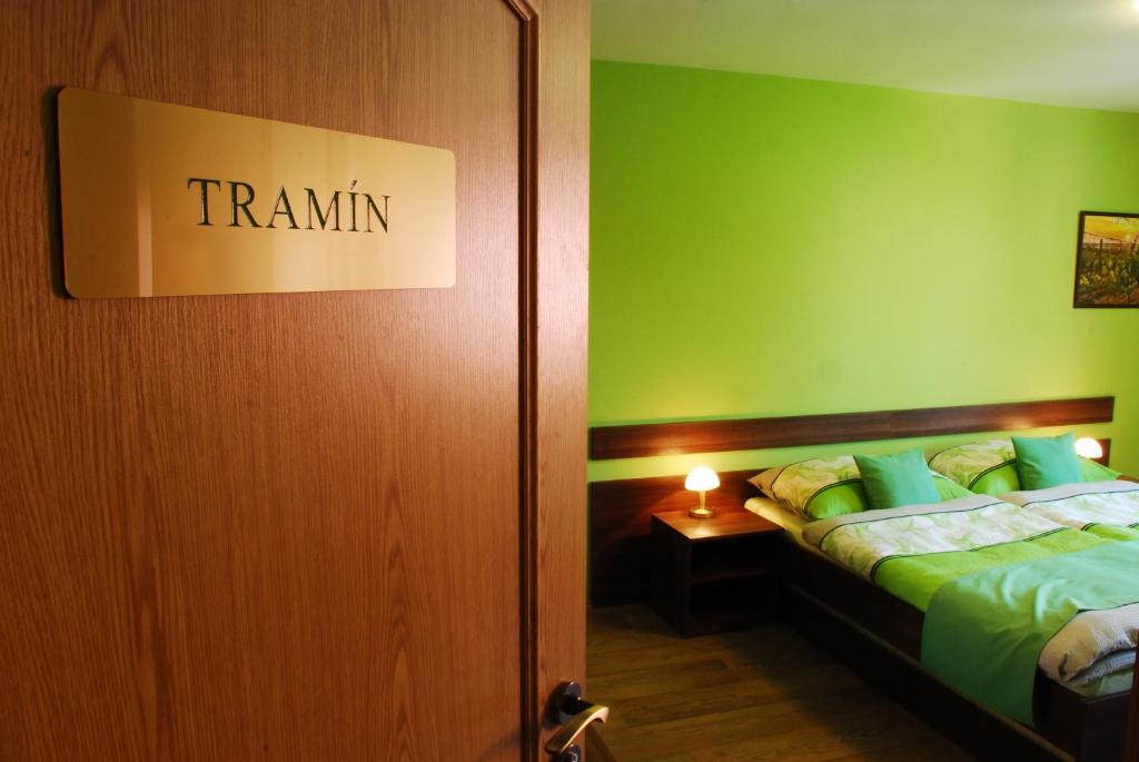 Habitación con cama con pared verde en Vinařství Pastorek, en Čejkovice