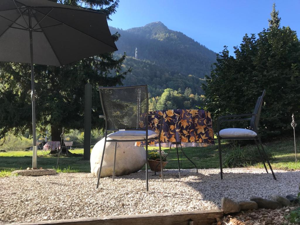 a couple of chairs and an umbrella on a field at Tor zum Kandertal beim Niesen/Mülenen in Mülenen 