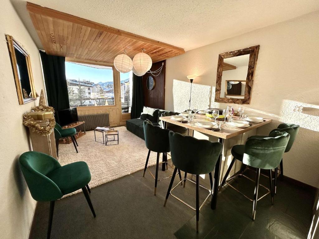 a dining room with a table and green chairs at Appartement Montgenèvre, 2 pièces, 6 personnes - FR-1-330D-52 in Montgenèvre