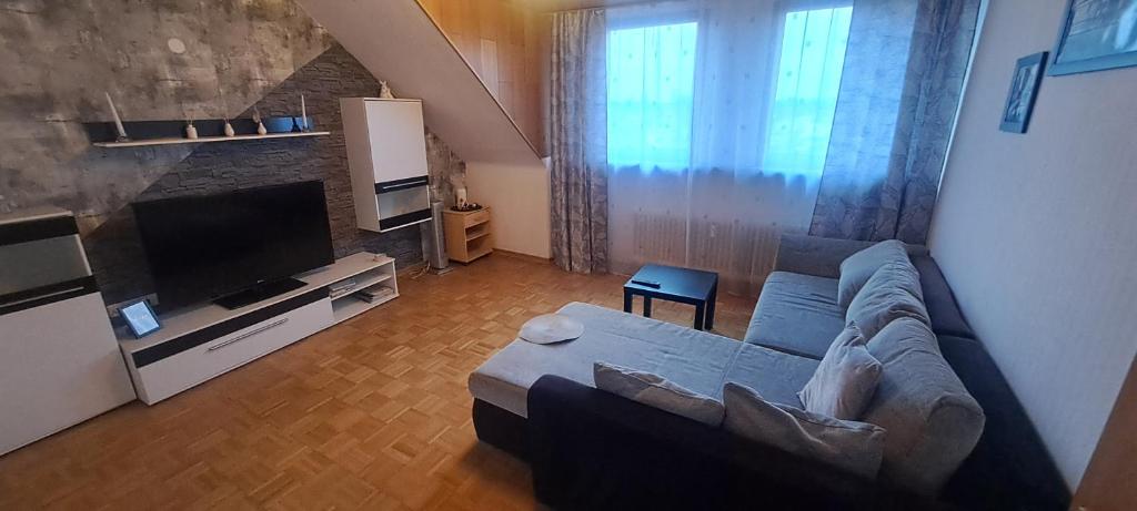 ein Wohnzimmer mit einem Sofa und einem Flachbild-TV in der Unterkunft Unterkunft A.Lambrecht in Oberhausen