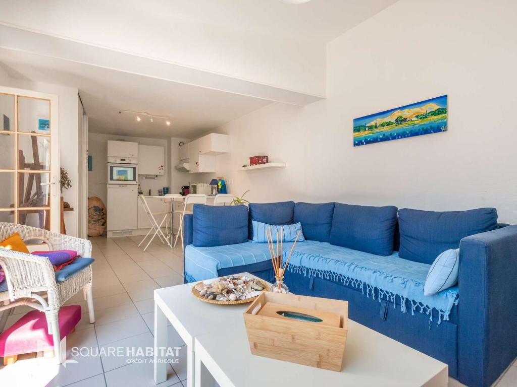 ein Wohnzimmer mit einem blauen Sofa und einem Tisch in der Unterkunft Villa Wimereux, 3 pièces, 4 personnes - FR-1-675-30 in Wimereux