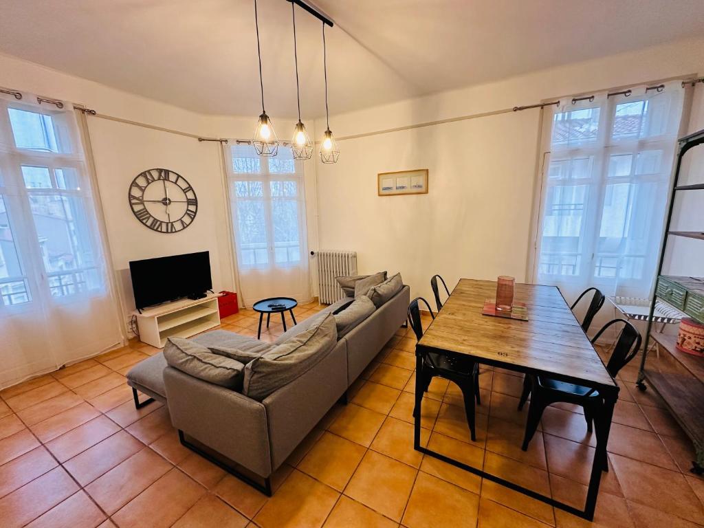 un salon avec un canapé et une table dans l'établissement Appartement Lumineux et Spacieux 2 Chambres avec Parking Gratuit dans la Rue, à Perpignan