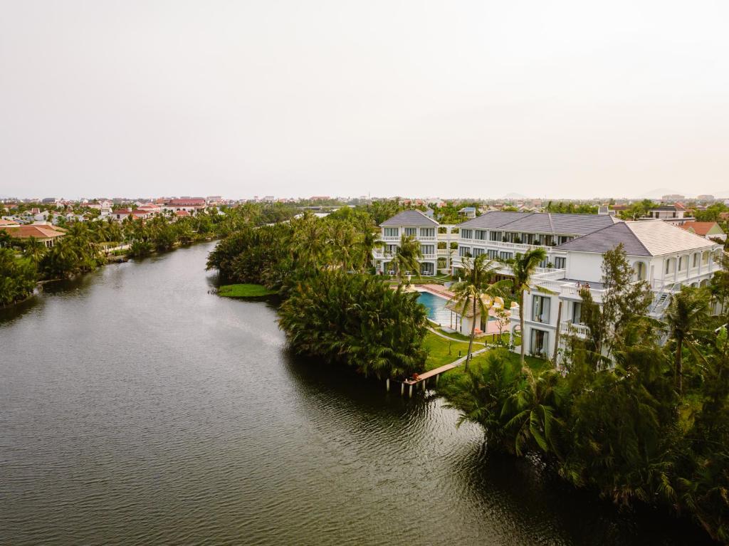 an aerial view of a river with houses and trees at Moodhoian Riverside Resort & Spa in Hoi An