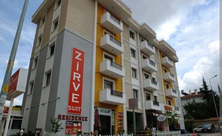a large building with a sign on the side of it at Zirve Suit Residance in Talas
