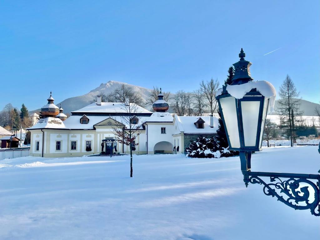 a street light in the snow in front of a house at Kaštieľ Kubínyi in Dolný Kubín