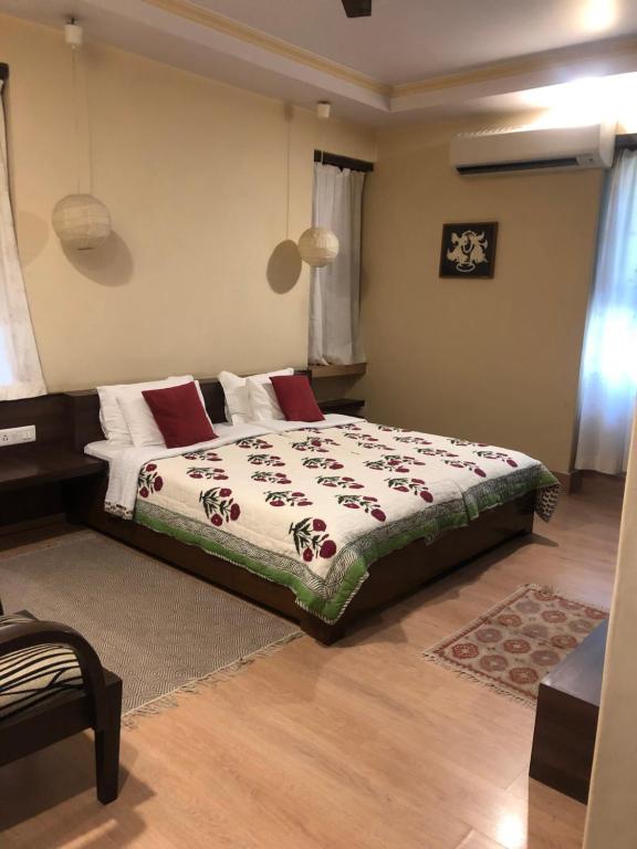 um quarto com uma cama grande e almofadas vermelhas em Magpie Villa em Jaipur