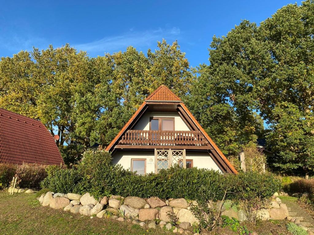 una casa con techo de gambrel y balcón en Finnhäuser am Vogelpark - Haus Elke, en Marlow