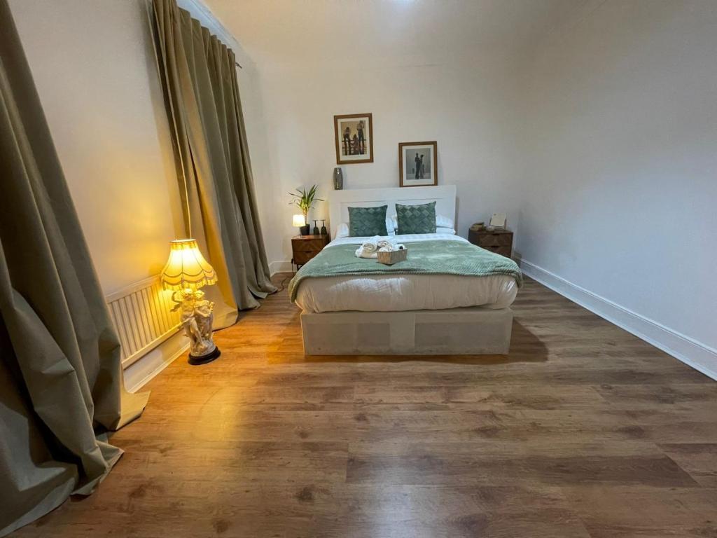 Un dormitorio con una cama y una lámpara. en Park View Homestay, en Barking