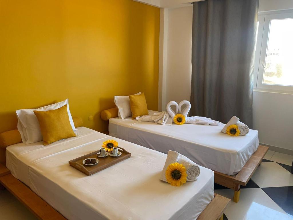 two beds in a room with sun flowers on them at Residencial Sol Point Art in Ponta do Sol