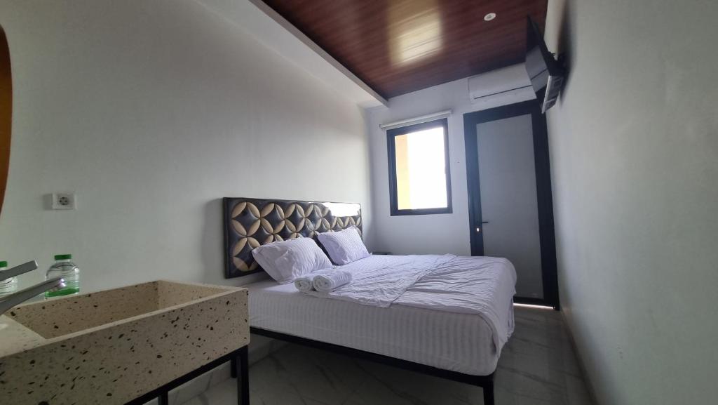 a small bedroom with a bed with a window at Batik Inn Semarang in Semarang