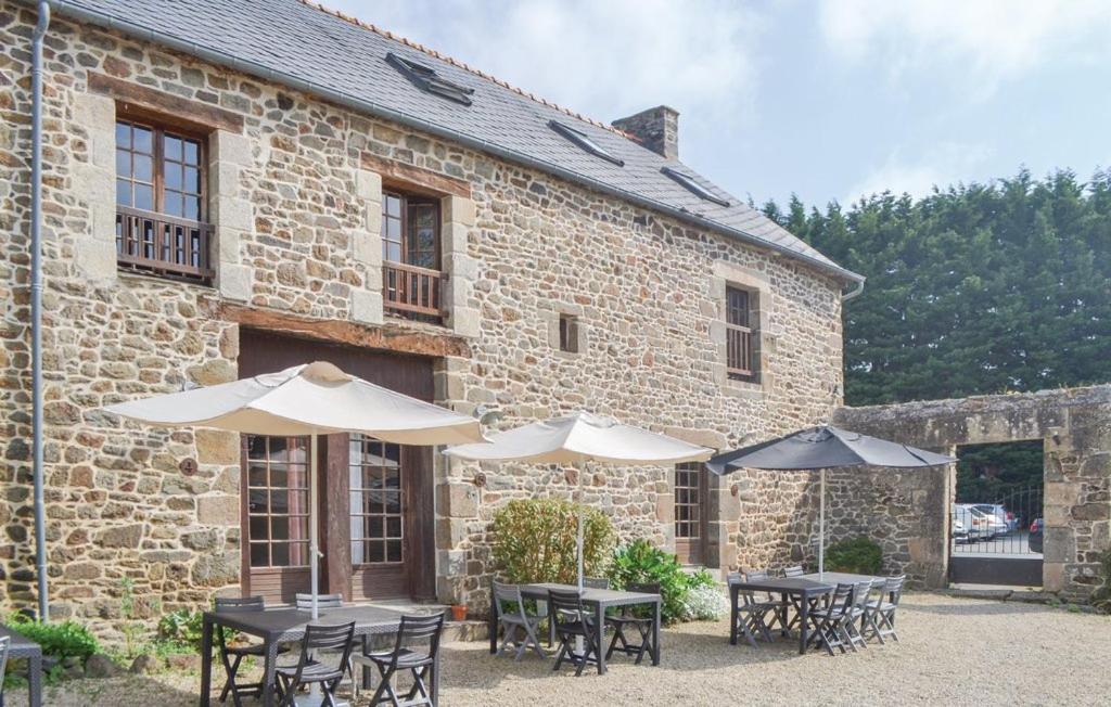 un groupe de tables et de parasols devant un bâtiment dans l'établissement Les 3 rossignols, à Taden