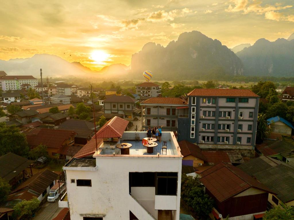 una vista de una ciudad con la puesta de sol en el fondo en Easy go backpacker hostel, en Vang Vieng
