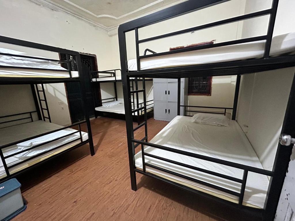 a room with three bunk beds in a room at NHÀ AN in Hanoi
