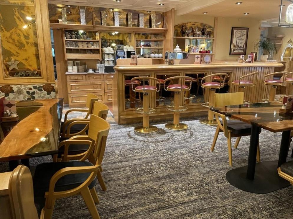 un bar con mesas de madera y sillas en un restaurante en Hotel - Café - Konditorei Schröckmayr-Kastner en Neufelden