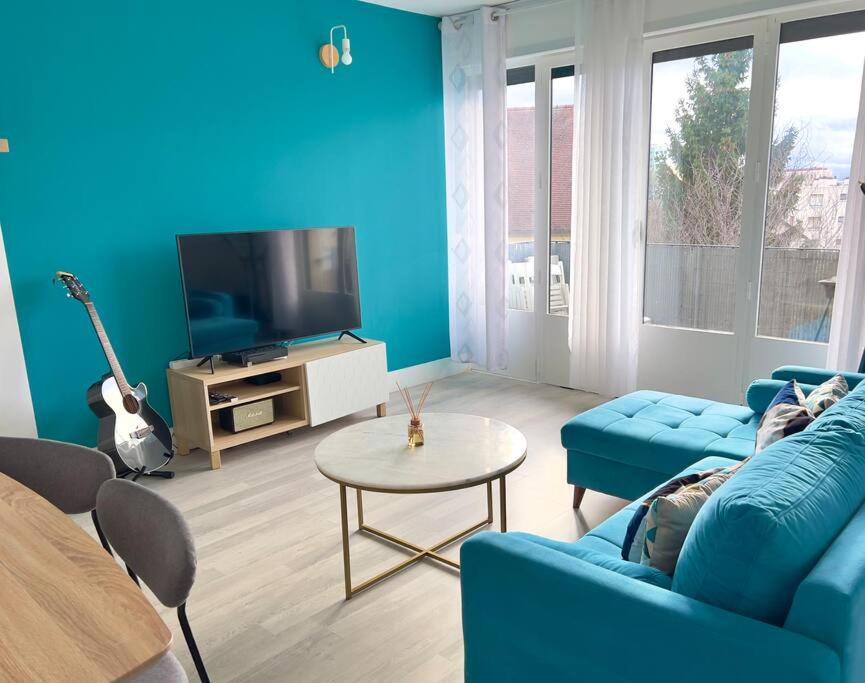 sala de estar con paredes azules y sofá azul en Proche Paris - Parking - 2 Chambres - 5 personnes, en Fresnes