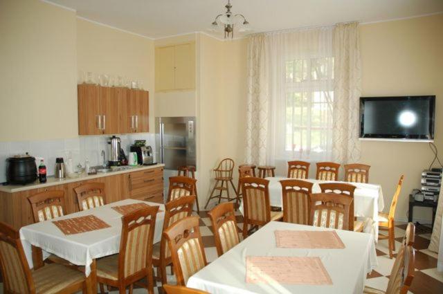 a kitchen with a table and chairs and a table and a kitchen with at Willa Nimfa -Również na wyłączność dla Grup nocleg z wyżywieniem in Szklarska Poręba