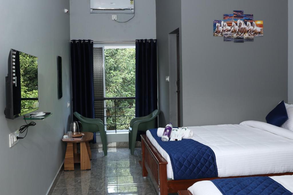 um quarto com 2 camas e uma janela em Bay Walk Residency em Auroville
