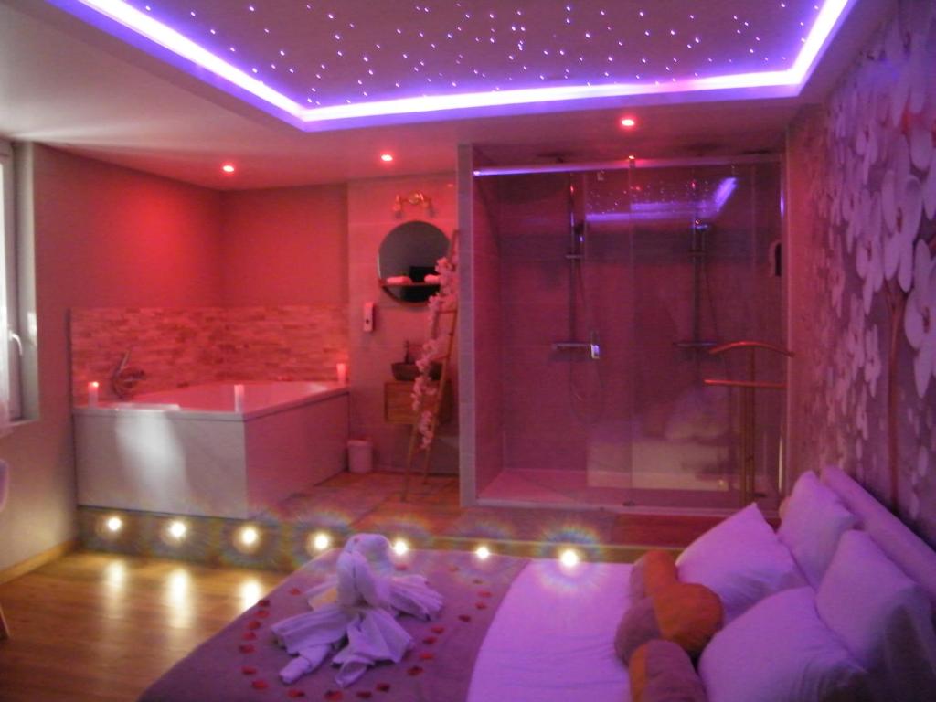 a bathroom with a tub and a shower with a child sitting on a couch at Studio Love Spa Baignoire XXL Port Vieux La Ciotat in La Ciotat