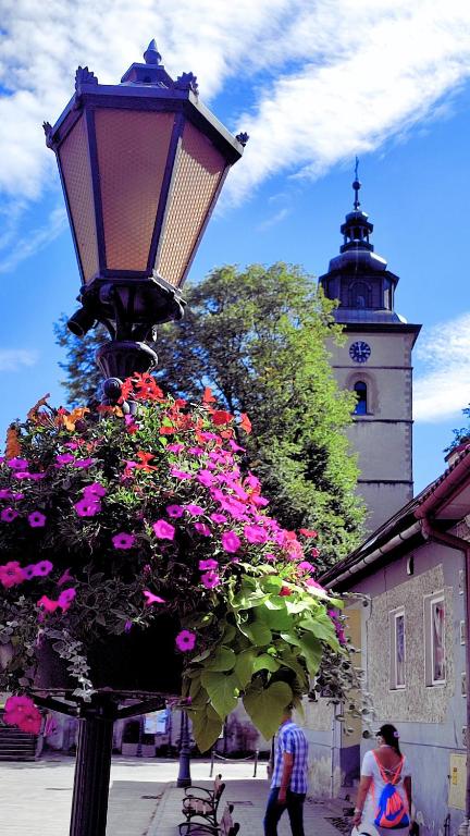 a street light with a bunch of flowers next to a building at Chwile w Starym Sączu, sauna i beczka in Stary Sącz
