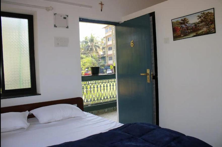 a bedroom with a bed and a door to a balcony at Hotel innovation inn in Baga