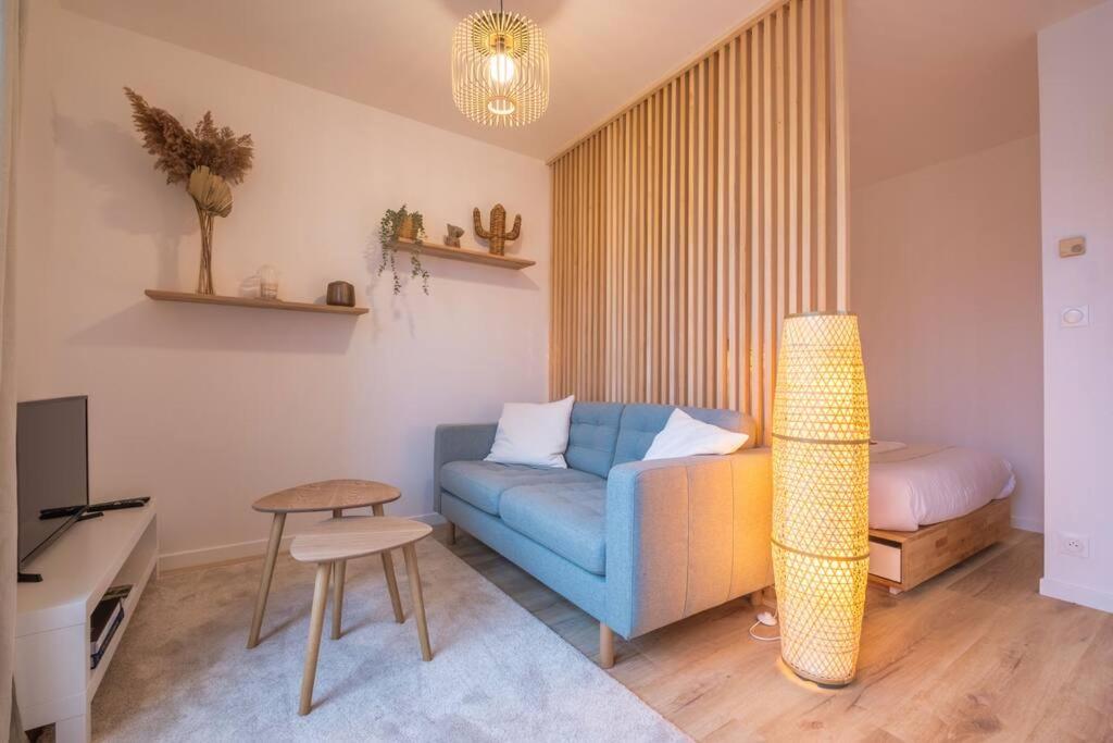 un salon avec un canapé bleu et une table dans l'établissement Le Jéroboam, à Reims